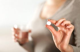 woman holding pill