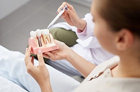 During consultation, a dentist explains how dental implants work