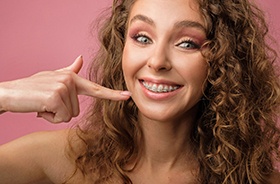Happy young woman pointing at her dental braces