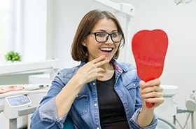 Woman looking at her smile in the mirror