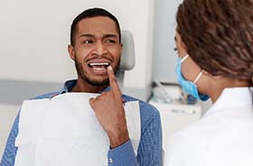Man pointing to his dental emergency in New Haven visiting his dentist