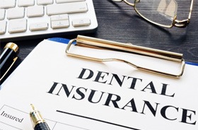 Dental insurance form on desk next to computer