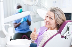 patient giving thumbs up after gum disease treatment in New Haven