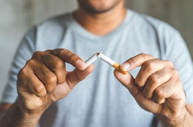 Man breaking cigarette, determined to quit smoking for good