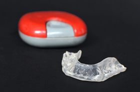Nightguard for bruxism in foreground, case in background