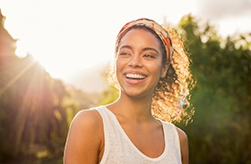 Smiling woman enjoying money-saving benefits of dental implants 