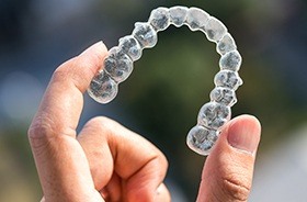 Hand holding a clear alignment tray