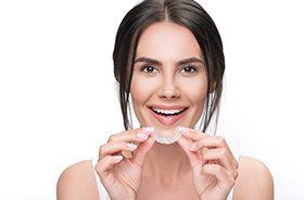 Woman placing her Invisalign tray