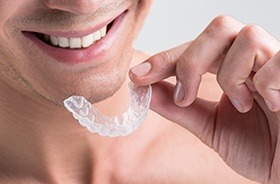 Closeup of man holding Invisalign tray