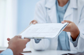 Dental team member handing clipboard to patient