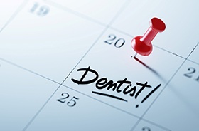 Preventive dental appointment marked on calendar with red thumbtack