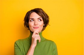 Woman wearing green turtleneck, has a curious expression on her face