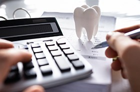 Using pen and calculator to figure root canal cost