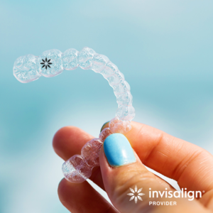 Hand holding clear aligner to advertise Invisalign promotion