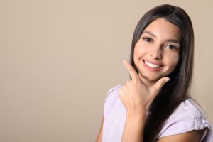 Woman showing smile after visiting cosmetic dentist in New Haven