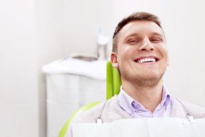 Dental patient smiling after receiving emergency care