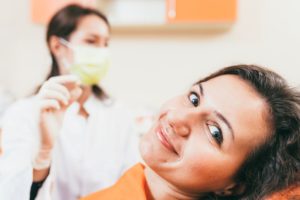 Patient smiling while dental team member holds extracted tooth